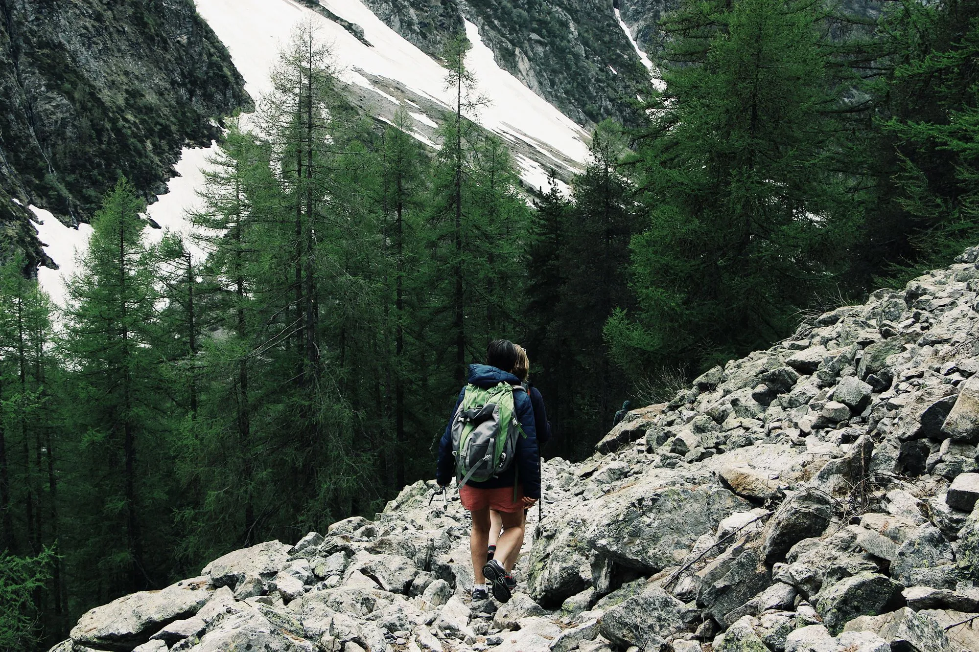 Randonneur avec un sac à dos sur un pierrier en forêt de montagne